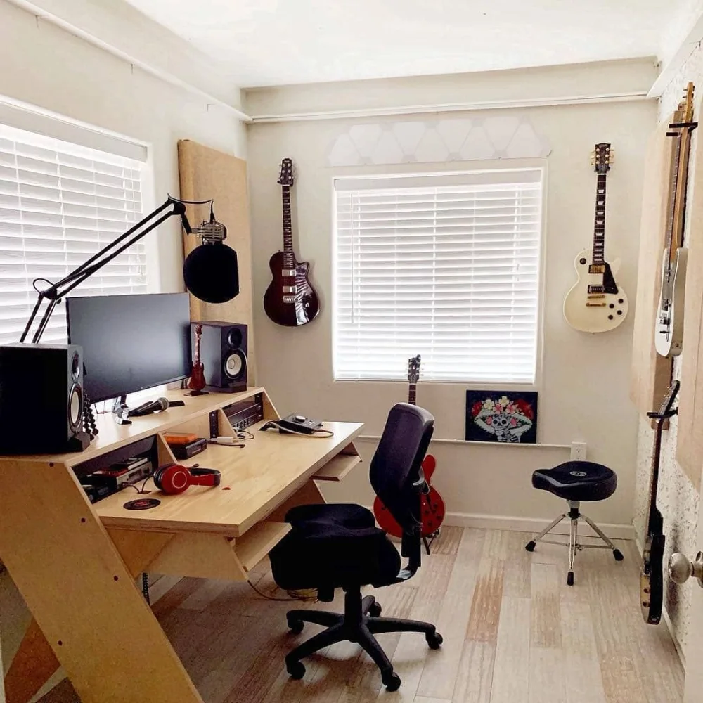 Home recording studio with guitars, monitors, and a custom work desk